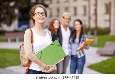 Education, Campus, Friendship And People Concept - Group Of Happy Teenage Students With School Folders