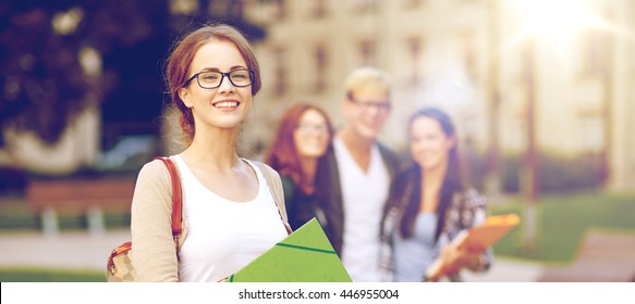 Education, Campus, Friendship And People Concept - Group Of Happy Teenage Students With School Folders