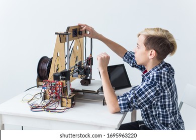 Education, children, technology concept - teen boy is printing on 3d printer.