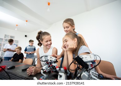 Education, Children, Technology, Science And People Concept - Group Of Happy Kids With Laptop Computer Building Robots At Robotics School Lesson