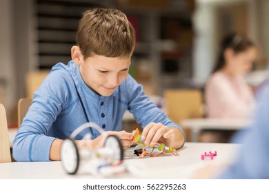 education, children, technology, science and people concept - close up of boy building robot at robotics school lesson