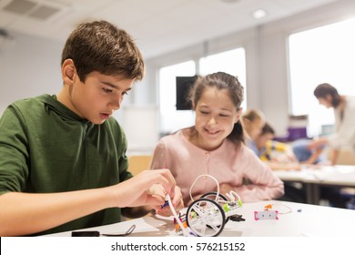 Education, Children, Technology, Science And People Concept - Happy Kids Building Robots At Robotics School Lesson