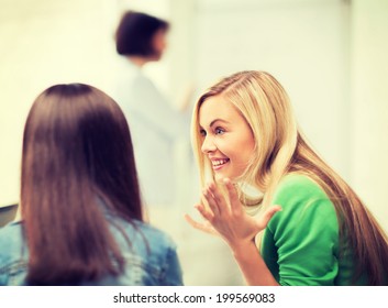 education concept - attractive student girl gossiping in lecture at school - Shutterstock ID 199569083