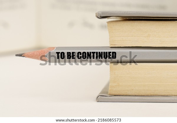 Education concept. In the\
book between the pages lies a pencil with the inscription - TO BE\
CONTINUED
