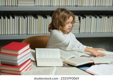 Education Concept. Child reads books in the library. Schoolkid with book in school library. Kids literature for reading. Learning from books. School education and clever talented pupil genius. - Shutterstock ID 2331993069