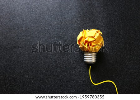 Education concept image. Creative idea and innovation. Crumpled paper as light bulb metaphor over black background
