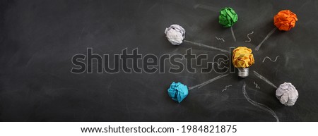 Education concept image. Creative idea and innovation. Crumpled paper as light bulb metaphor over blackboard