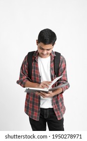 Education concept : Indian college student holding bag and reading book on white background