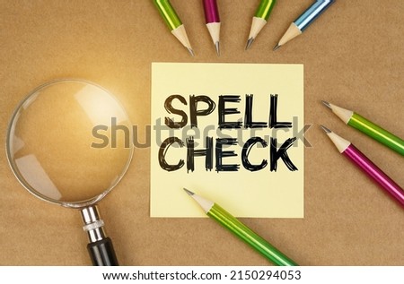 Education concept. On the table are pencils, a magnifying glass and a sticker with the inscription - Spell Check