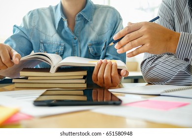 Education concept. Students studying and brainstorming campus concept. Close up of students discussing their subject on books textbooks and writing to notebook. Selective focus. - Shutterstock ID 651580948