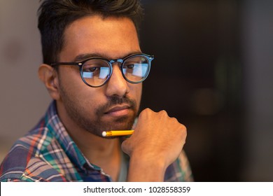 Education, Deadline And People Concept - Close Up Of Creative Man In Glasses Working At Night Office And Thinking