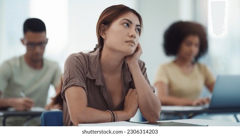 Education, depression and girl university student in a classroom bored, adhd or daydreaming during lecture. Thinking, anxiety and female learner distracted in class, contemplation, boredom or sad - Powered by Shutterstock