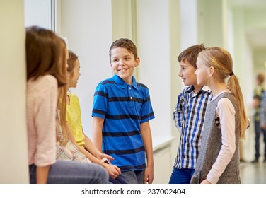 education, elementary school, children, break and people concept - group of smiling school kids talking in corridor