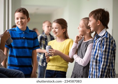 Education, Elementary School, Drinks, Children And People Concept - Group Of School Kids With Soda Cans Talking In Corridor