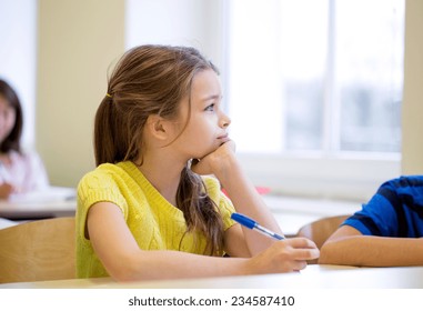 education, elementary school, learning and people concept - school girl with pen being bored in classroom - Powered by Shutterstock