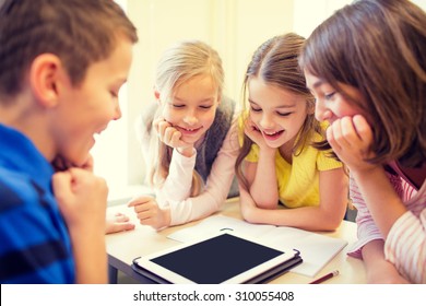 Education, Elementary School, Learning, Technology And People Concept - Group Of School Kids With Tablet Pc Computer Having Fun On Break In Classroom