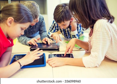 Education, Elementary School, Learning, Technology And People Concept - Group Of School Kids With Tablet Pc Computer Having Fun On Break In Classroom