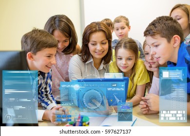 Education, Elementary School, Learning, Technology And People Concept - Group Of Kids With Teacher Looking To Tablet Pc Computer In Classroom And Virtual Screen Projection