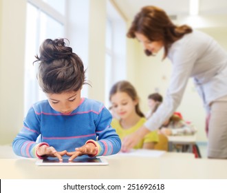 Education, Elementary School, Technology And Children Concept - Little Student Girl With Tablet Pc Over Classroom And Teacher Background