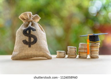 Education Expense Or Student Loan For Post Secondary Education Concept : Dollar Bag, Graduation Cap On Row Of Coins On A Table, Depicts Loan Or Money Designed To Help Students Pay For Associated Fees