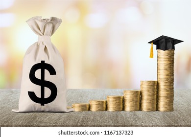 Education Expense Or Student Loan For Post Secondary Education Concept : Dollar Bag, Graduation Cap On Row Of Coins On A Table, Depicts Loan Or Money Designed To Help Students Pay For Associated Fees