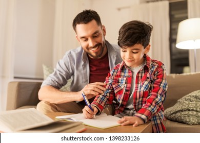 education, family and homework concept - happy father and son with book writing to notebook at home - Powered by Shutterstock