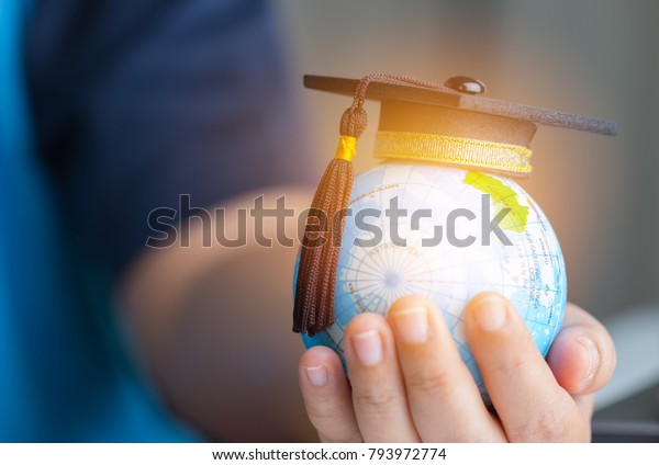 Education in Global world, Graduation cap on\
Businessman holding Earth globe model map with Radar background in\
hands. Concept of global business study, abroad educational, Back\
to School.