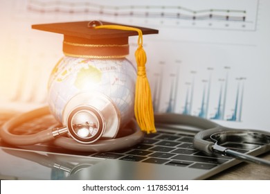 Education Graduate Study Medical Hostpital International Concept: Graduation Cap Earth Globe Model Map With Marketing Graph Report On Screen With Stethoscope On Notebook Computer Desk In Clinic