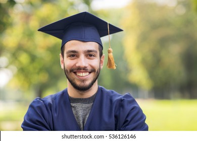 Education, Graduation And People Concept - Close Up Of Happy Student In Mortar Boards And Bachelor Gown Outdoors