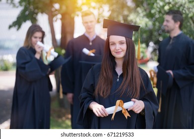 education, graduation and people concept - group of happy international students in mortar boards and bachelor gowns with diplomas - Shutterstock ID 671219533