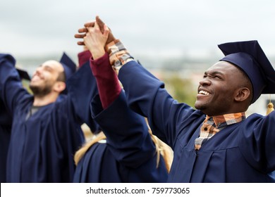 education, graduation and people concept - group of happy international students in mortar boards and bachelor gowns holding hands and celebrating success - Powered by Shutterstock