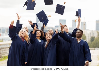 education, graduation and people concept - group of happy international students in bachelor gowns throwing mortar boards up in the air