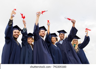 education, graduation and people concept - group of happy international students in mortar boards and bachelor gowns with diplomas celebrating success - Powered by Shutterstock