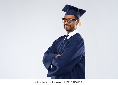 Education, Graduation And People Concept - Happy Smiling Indian Male Graduate Student In Mortar Board And Bachelor Gown Over Grey Background