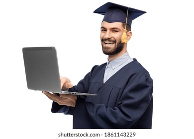 Education, Graduation And People Concept - Happy Smiling Male Graduate Student In Mortar Board And Bachelor Gown With Laptop Computer Over White Background