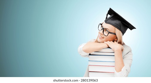 Education, Happiness, Graduation And People Concept - Picture Of Happy Student In Mortar Board Cap With Stack Of Books Daydreaming Over Blue Background