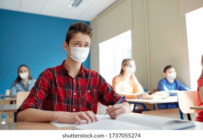 Education, Healthcare And Pandemic Concept - Group Of Students Wearing Face Protective Medical Mask For Protection From Virus Disease With Books At School Lesson