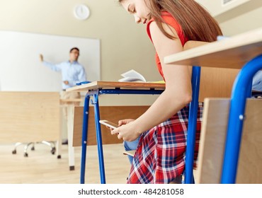 Education, High School, Learning, Technology And People Concept - Student Girl With Smartphone Texting On Lesson