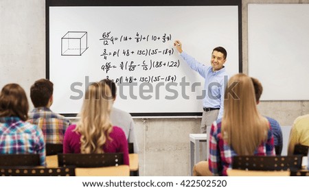 education, high school, mathematics and people concept - smiling teacher standing in front of students and writing mathematical equalities on white board in classroom