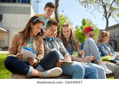 Education, High School And People Concept - Group Of Happy Teenage Students With Notebooks Learning At Campus Yard