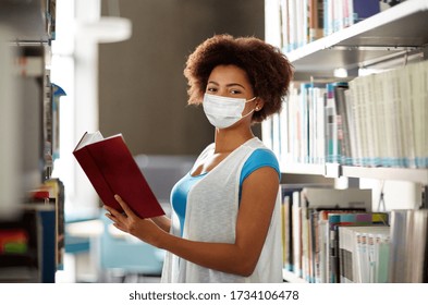 Education, High School, University, Learning And People Concept - African American Student Girl Wearing Face Protective Medical Mask For Protection From Virus Disease Reading Book At Library