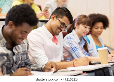 Bildungs-, Highschool-, Universitäts-, Lern- und People-Konzept - Gruppe internationaler Schüler mit Notizbüchern und Kaffeeschreibungstest im Vorlesungssaal