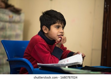 Education at home concept    Cute little Pakistan/Asian boy studying completing home work study