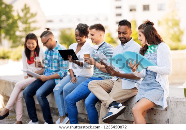 education, international and technology concept\
- group of happy exchange students with notebooks and tablet pc\
computer outdoors