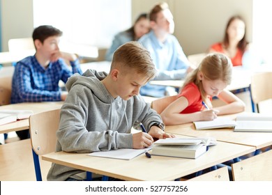 education, learning and people concept - group of students with books writing school test - Shutterstock ID 527757256