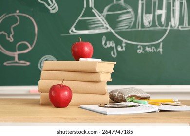 Education and learning with stack of books, red apples, and school supplies on wooden desk