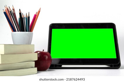 Education Materials In The Box, With Ipad Green Screen And Books Isolated On White Background. Back To School Poaster Concept Design