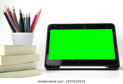 Education Materials In The Box, With Ipad Green Screen And Books Isolated On White Background. Back To School Poaster Concept Templates