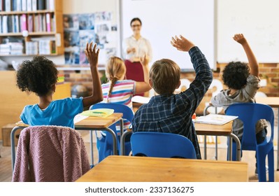 Education, question with group of children in classroom and raise their hands to answer. Learning or support, diversity and teacher teaching with young students in class of school building together - Shutterstock ID 2337136275