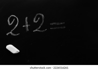 education school concept. elementary arithmetic addition task written on a black chalkboard requiring a solution